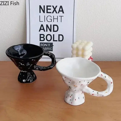 Two decorative ceramic mugs with unique sculpted design in glossy black and white speckled colors on wooden surface