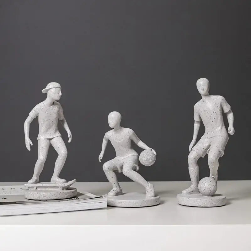 Set of three white speckled resin abstract sports player sculptures in dynamic poses for grey and white living room decorbites decor