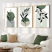 Set of three DecorBites™ abstract green plants wall art pieces with minimalist green and black leaf designs in light wood frames