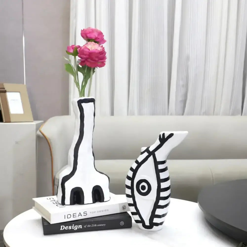 White ceramic vases with bold black geometric eye pattern and stylized giraffe design for living room decor