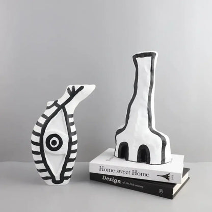 White ceramic vases with bold black geometric eye pattern featuring stylized fish and elongated figure for living room decor