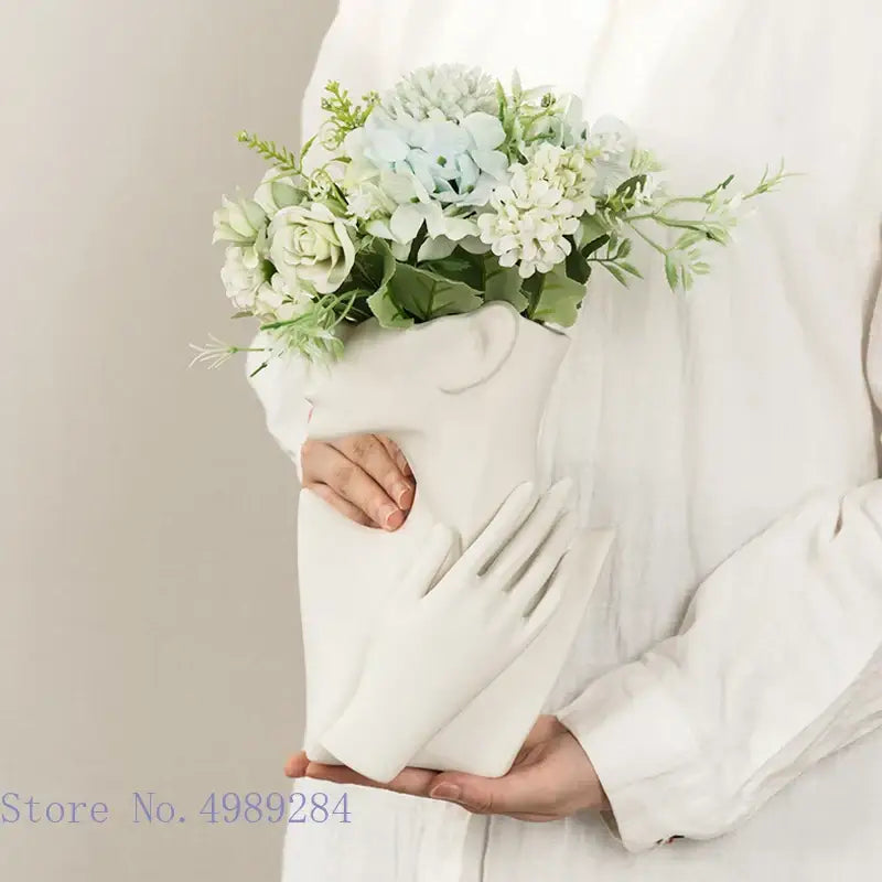 Abstract white ceramic vase portrait ornament with half face design holding blue and white hydrangeas for living room decor