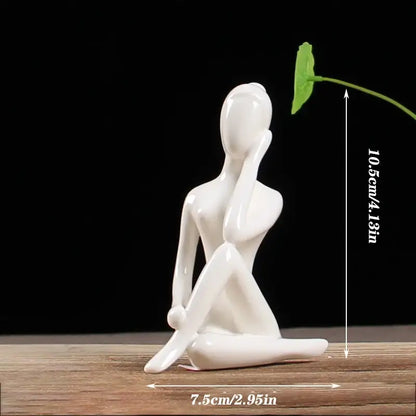Abstract white porcelain yoga figure featuring a seated woman holding a green leaf for living room decorbites abstract yoga decor