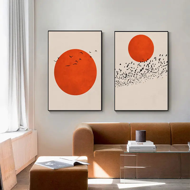 Two minimalist nordic style canvas prints featuring bold orange circles on cream background in sleek black frames winter morning landscape