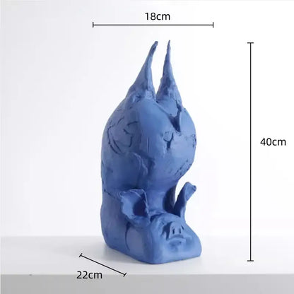 A blue ceramic decorbites cartoon pig sculpture with inverted head textured surfaces and pointed ears for bedroom decor