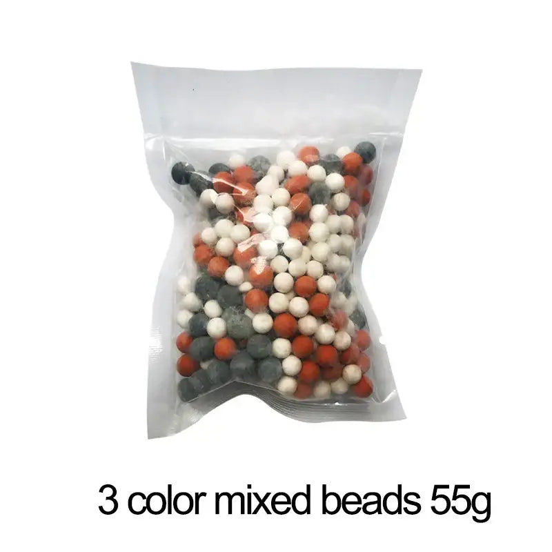 A clear plastic bag with 55g of mixed orange white and gray filter beads for an adjustable high pressure shower head
