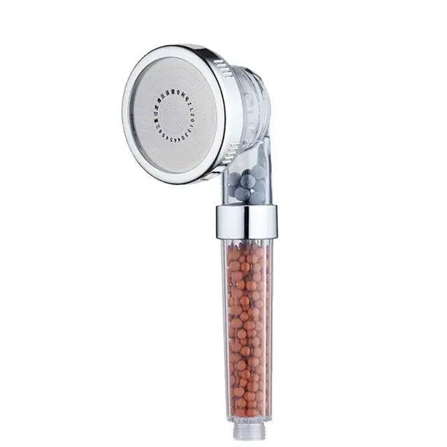 Adjustable shower head with chrome accents and transparent body containing orange and gray filtration beads
