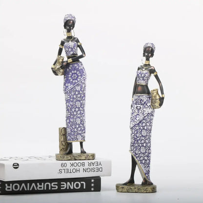 Two african woman sculptures in purple and gold patterned garments ideal for decorbites african woman decor