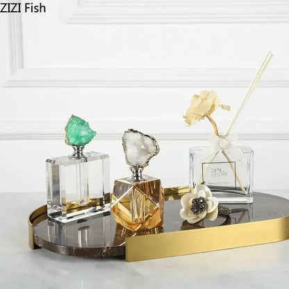 Two crystal agate stone perfume bottles with green and white geode stoppers for essential oils on gold tray