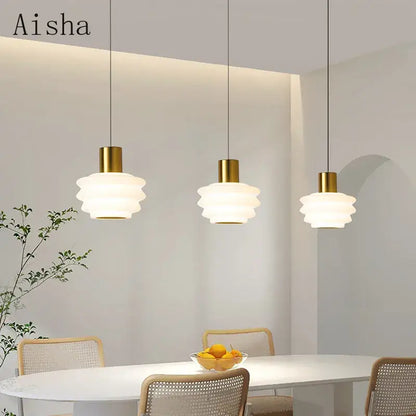 Three elegant gold Aisha pendant lights with layered frosted glass shades for bedroom decor and acrylic led hanging