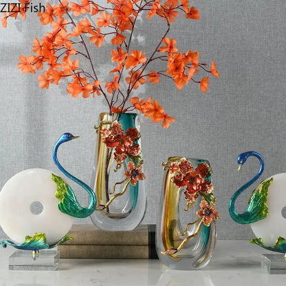 A translucent teal and gold blue gradient glass floral relief vase with intricate embellishments and matching swan decorbites figurines