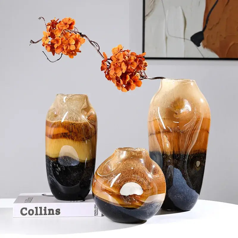 Three layered decorbites gradient glass vases with amber brown and black hues for irregular floral arrangement in living room