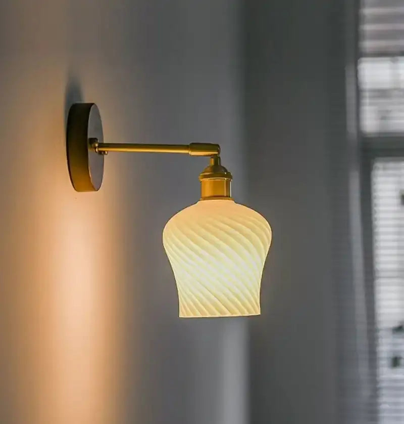 Amber and cream geometric glass pendant light featuring a twisted design and brass arm for dining room lighting