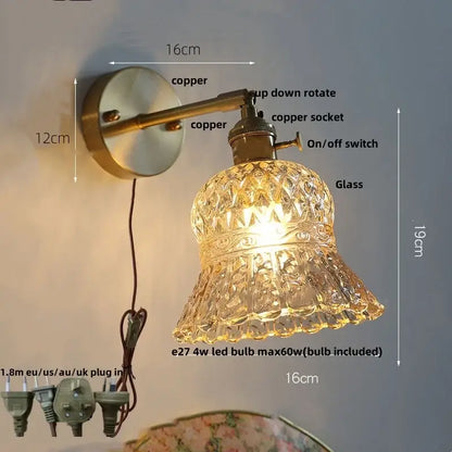 Antique brass-finished copper wall light fixture with faceted bell-shaped amber flower crystal glass shade and pull chain