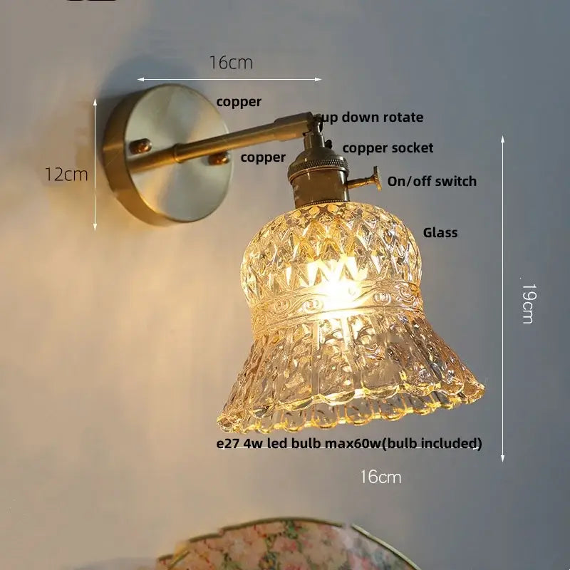 Antique brass-finished wall light fixture with faceted clear amber flower crystal glass shade and pull chain for bedroom