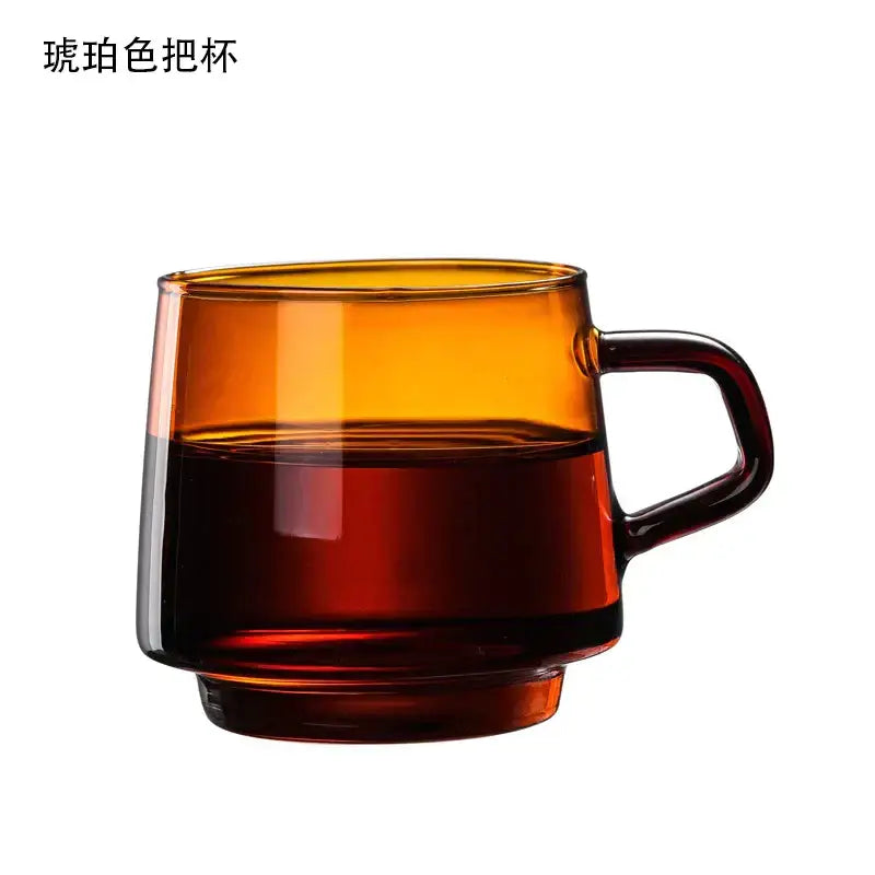 Amber-colored glass coffee mug with handle filled halfway with dark liquid by decorbites glass coffee mug