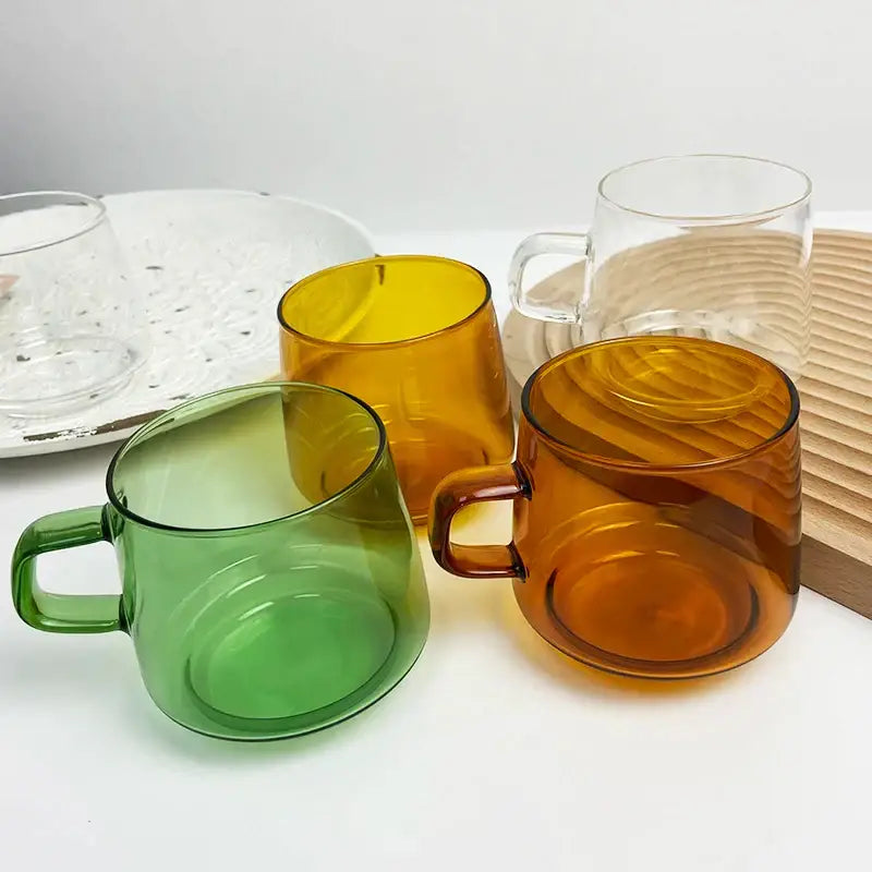 Set of colorful translucent decorbites glass coffee mugs in amber green and clear with sleek handles for tea and juice