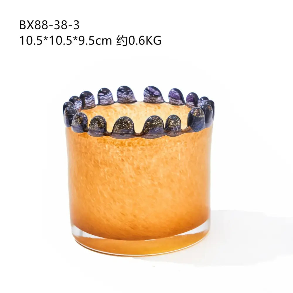Amber glass cylinder vase with textured orange glass, ornate black beaded rim, and colored lace purple accents for decor
