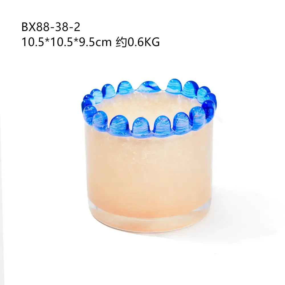 Translucent peach-colored amber glass cylinder vase with decorative blue beaded rim for living room decor