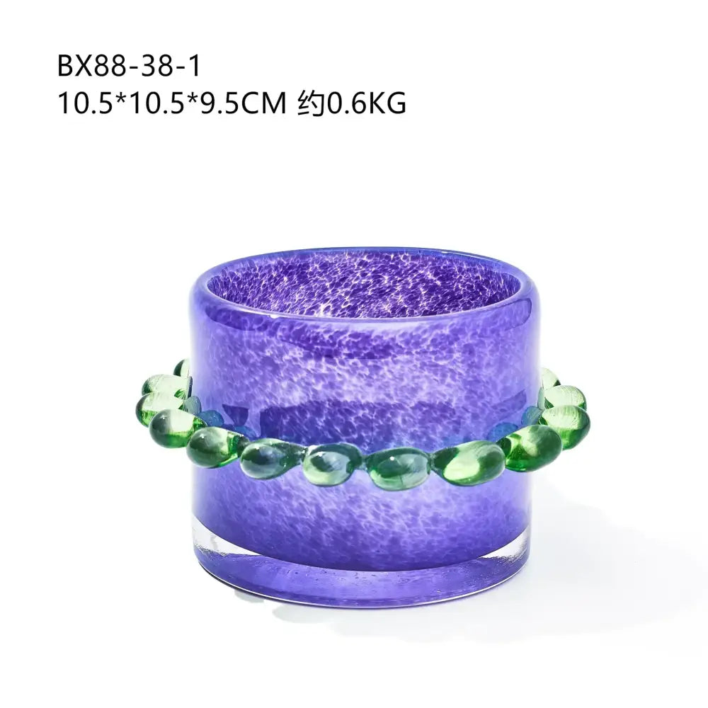 Purple glass cylinder candle holder with textured speckled surface and green teardrop beads for living room decor