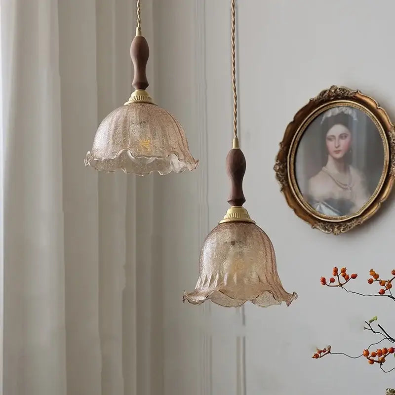 Two vintage-style pendant lamps with amber glass led textured shades and walnut wood stems for kitchen lighting