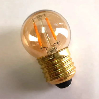Warm-toned decorbites amber glass vintage led bulb with brass screw base and glowing orange filaments for bedroom use