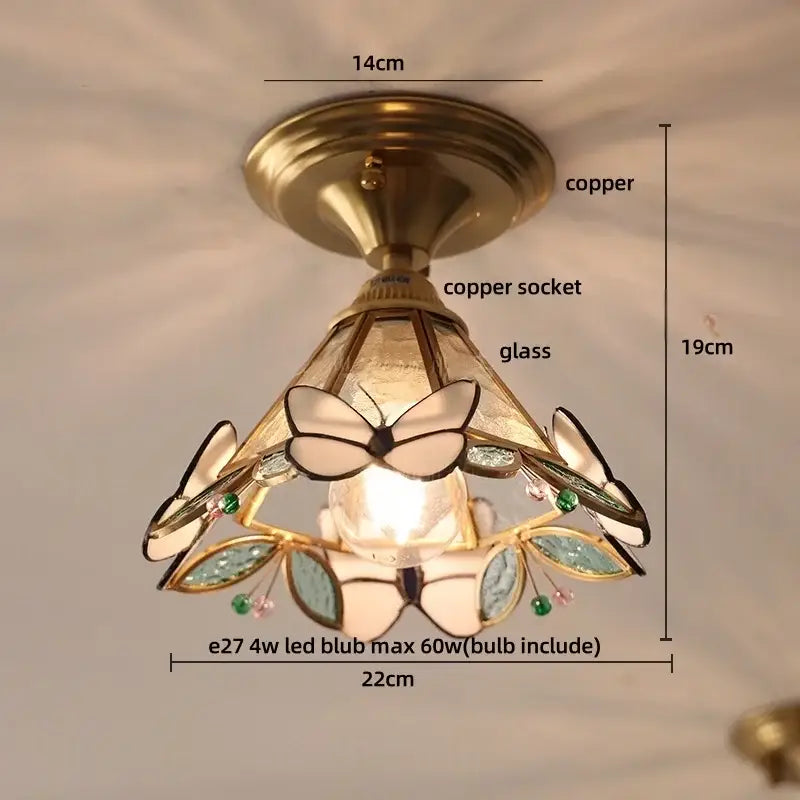 Brass-finished ceiling light with amber glass, stained butterfly panels, and wood copper led accents for dining room use