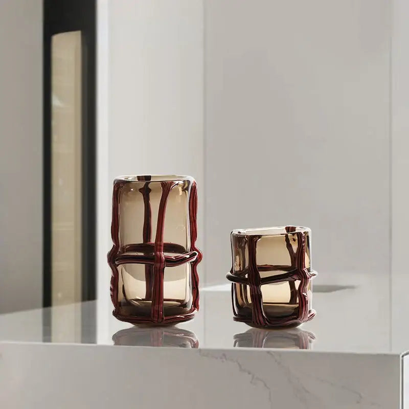 Two amber glass vases with intricate red brown woven wire frames for elegant home decor and decorative accents