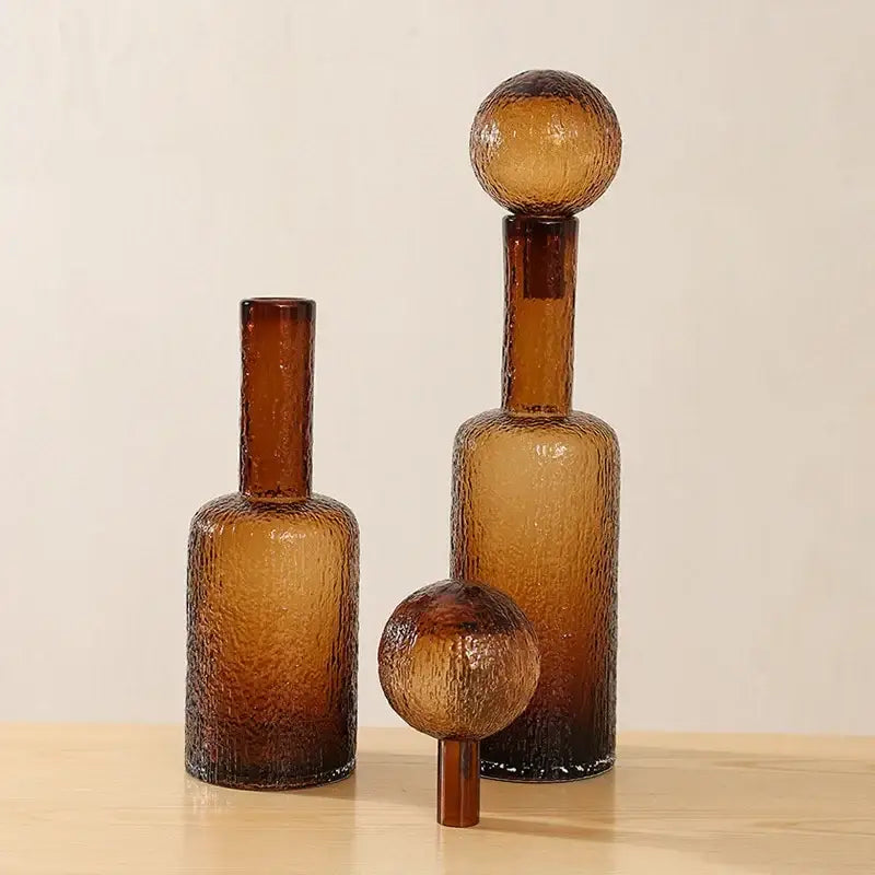Set of three amber textured decorbites clear glass decanters with spherical stoppers for living room decor