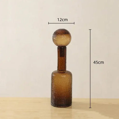 A textured amber glass decanter with a rounded top and slender neck from the decorbites clear glass vase set
