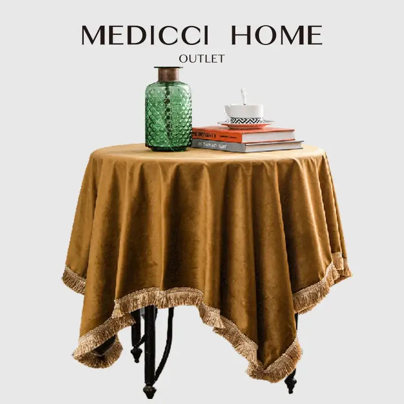 A rich gold velvet table cloth with fringed edge draped over a round table ideal for decorbites gold velvet wedding decor