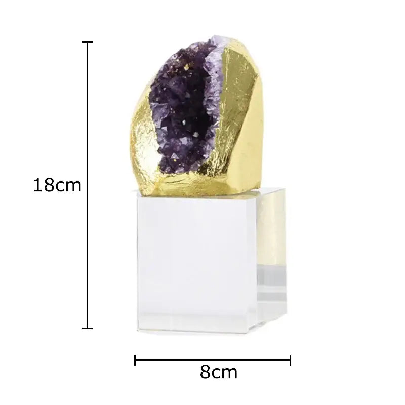 A striking 18cm amethyst crystal base geode with golden foil exterior and purple crystals on an acrylic desk ornament