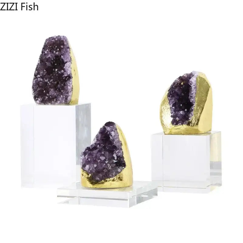 Three elegant amethyst crystal base geode sculptures with golden coating on clear acrylic bases as desk ornaments