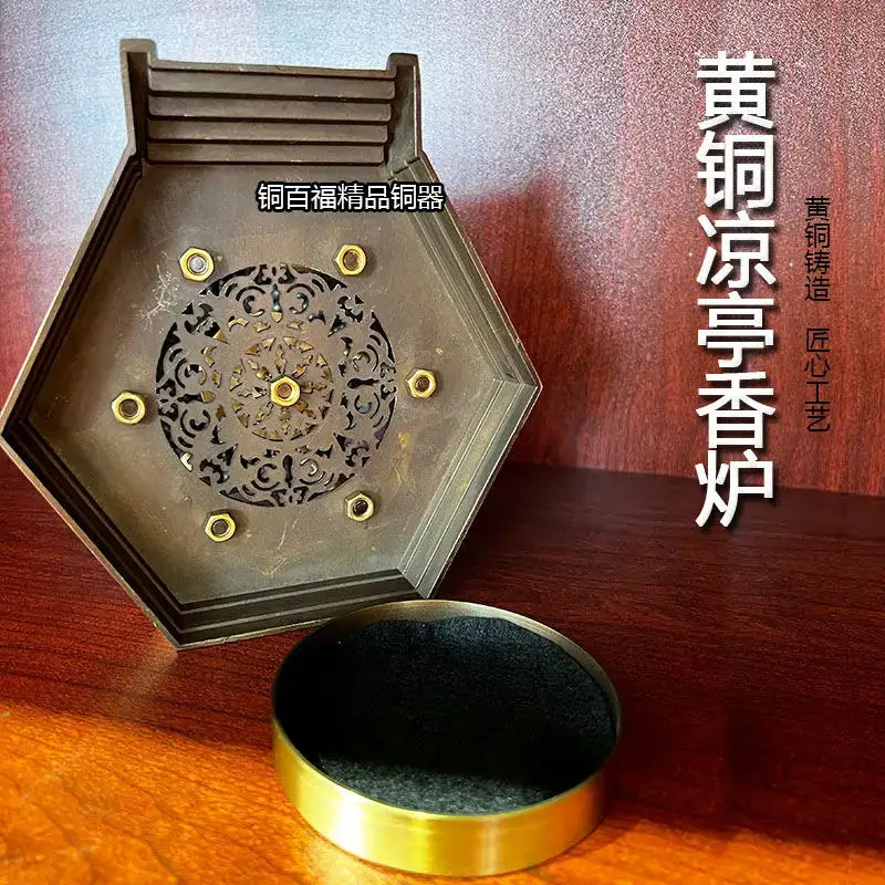 Hexagonal brass incense burner with floral cutouts and golden accents on a matching black felt lined base for living room decor