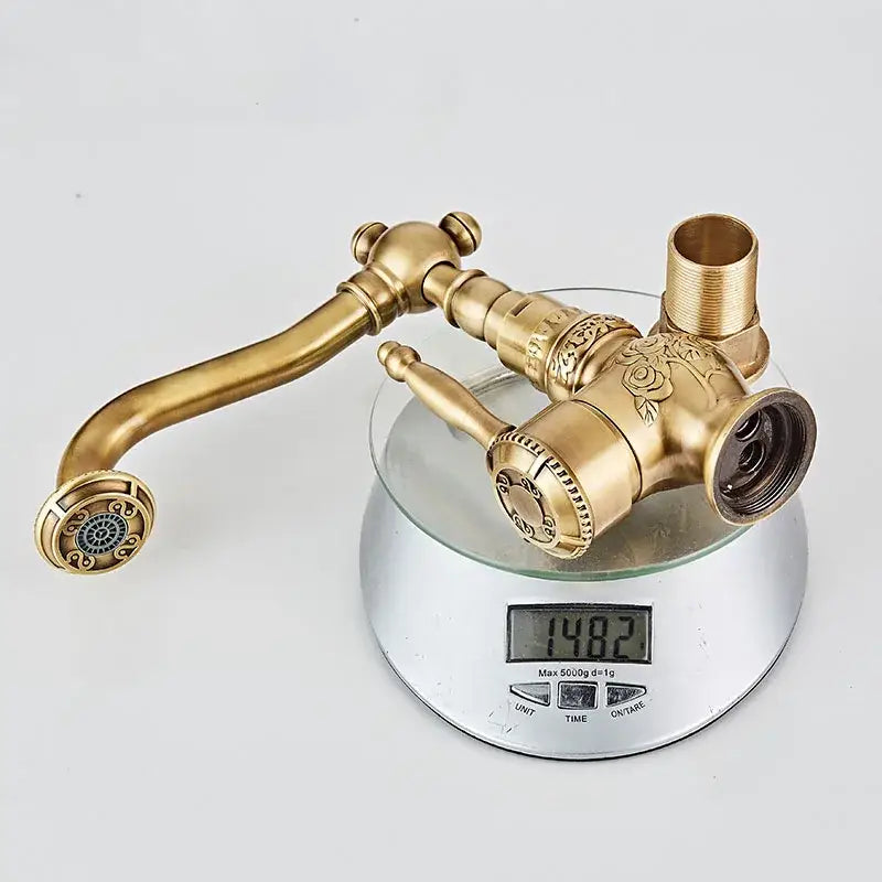 Antique black brass basin mixer tap with ornate rose engraving and curved swivel spout for bathroom basins
