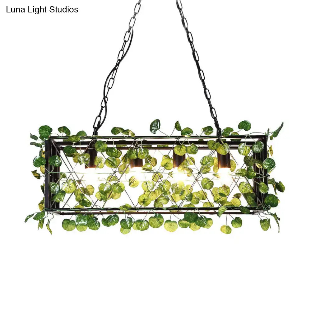 Rectangular metal island pendant in antique black with LED downlighting and artificial green leaves in wire mesh design