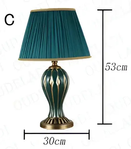 Antique blue ceramic desk lamp with teal pleated lampshade and gold trim on green and white brass base