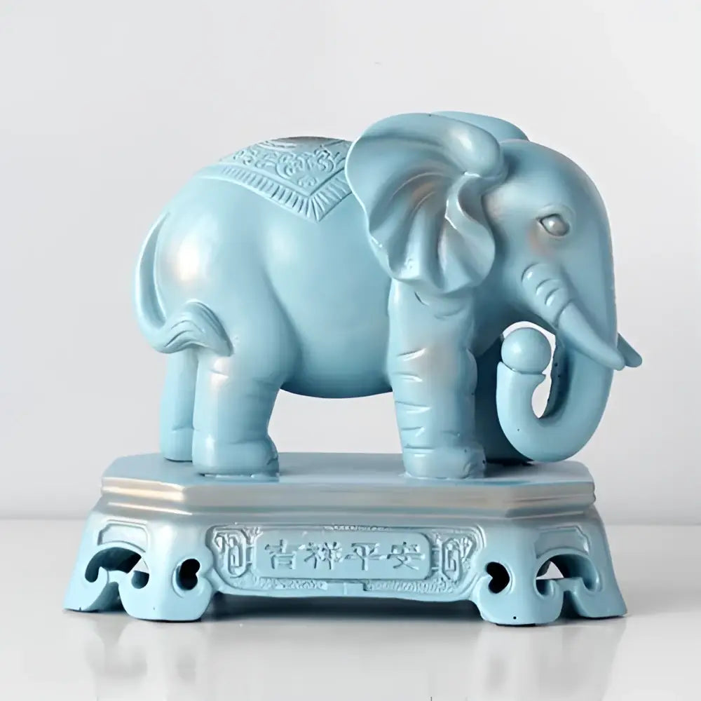 A light blue antique elephant couple resin statue with intricate engraved patterns on a matching pedestal for living room decor