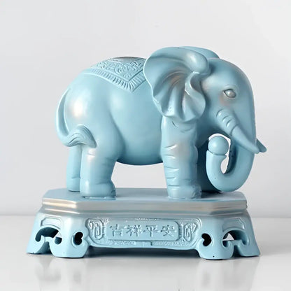 A light blue antique elephant couple resin statue with intricate engraved patterns on a matching pedestal for living room decor