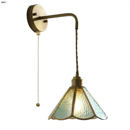 Antique brass-finished wall sconce with textured blue glass led shade and ornate twisted cord for decorbites blue glass lighting