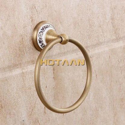 Antique brass towel ring with white ceramic backplate and black floral patterns in decorbites brass bathroom set