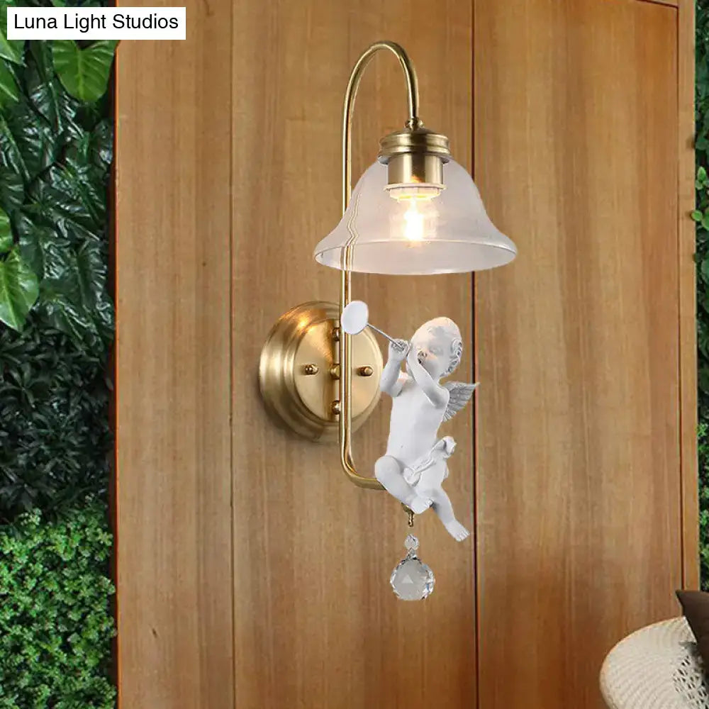 Antique brass angel glass sconce light with white ceramic cherub holding trumpet and clear glass detail