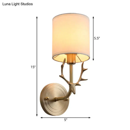 Antique brass antler wall sconce with cream fabric shade featuring a stylish design for bedroom lighting