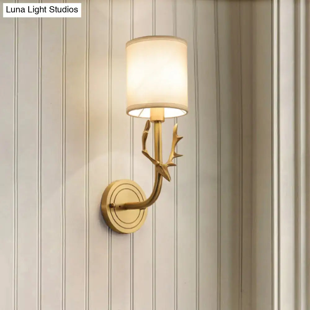 Antique brass antler wall sconce with gold-toned design and off-white fabric shade for stylish bedroom lighting