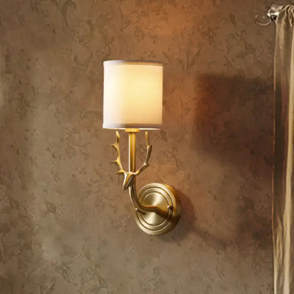 Antique brass wall sconce with deer antler design and off-white fabric shade for stylish bedroom lighting