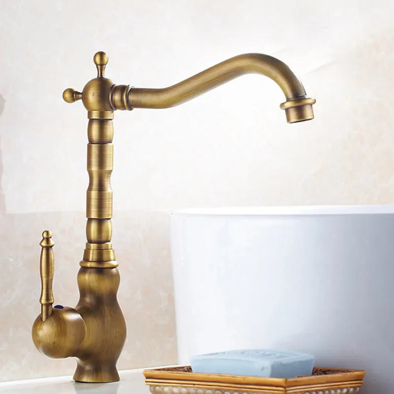 Antique brass basin faucet featuring a vintage-style ornate segmented spout and handle in brass finish