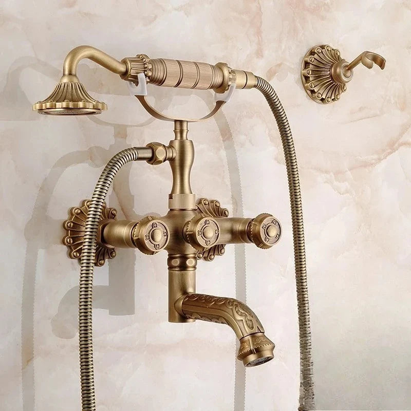 Antique brass bathtub shower set with vintage-style wall-mounted faucet and ornate detailing featuring three control knobs