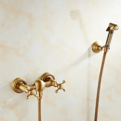 Antique brass bidet mixer faucet with ornate cross handles and matching handheld showerhead for bathroom use