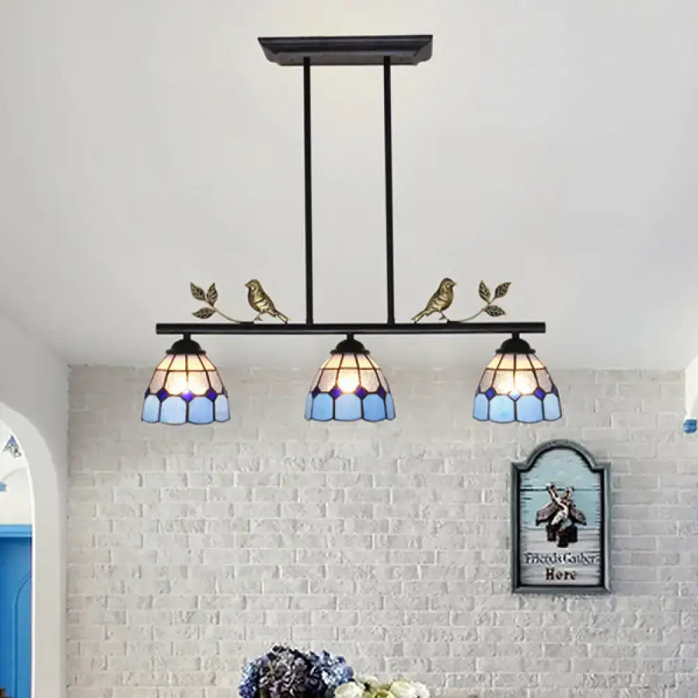 Three-light indoor island pendant with black blue tiffany-style stained glass shade and antique brass bird accents
