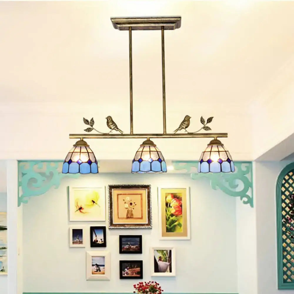 Antique brass indoor island pendant with three blue stained glass shades and decorative bird motifs